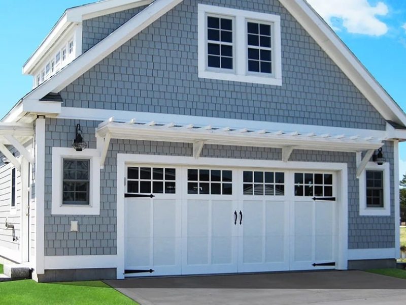 Classic carriage house wholesale garage doors with decorative hardware.
